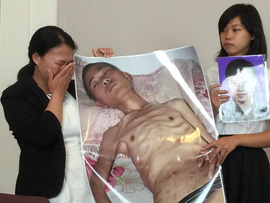 Xu Xinyang (R) and her mother, Chi Lihua, hold pictures of her late father, Xu Dawei. Xu was sentenced to eight years for practicing Falun Gong. He died just 13 days after he was released. (Jennifer Zeng/The Epoch Times)