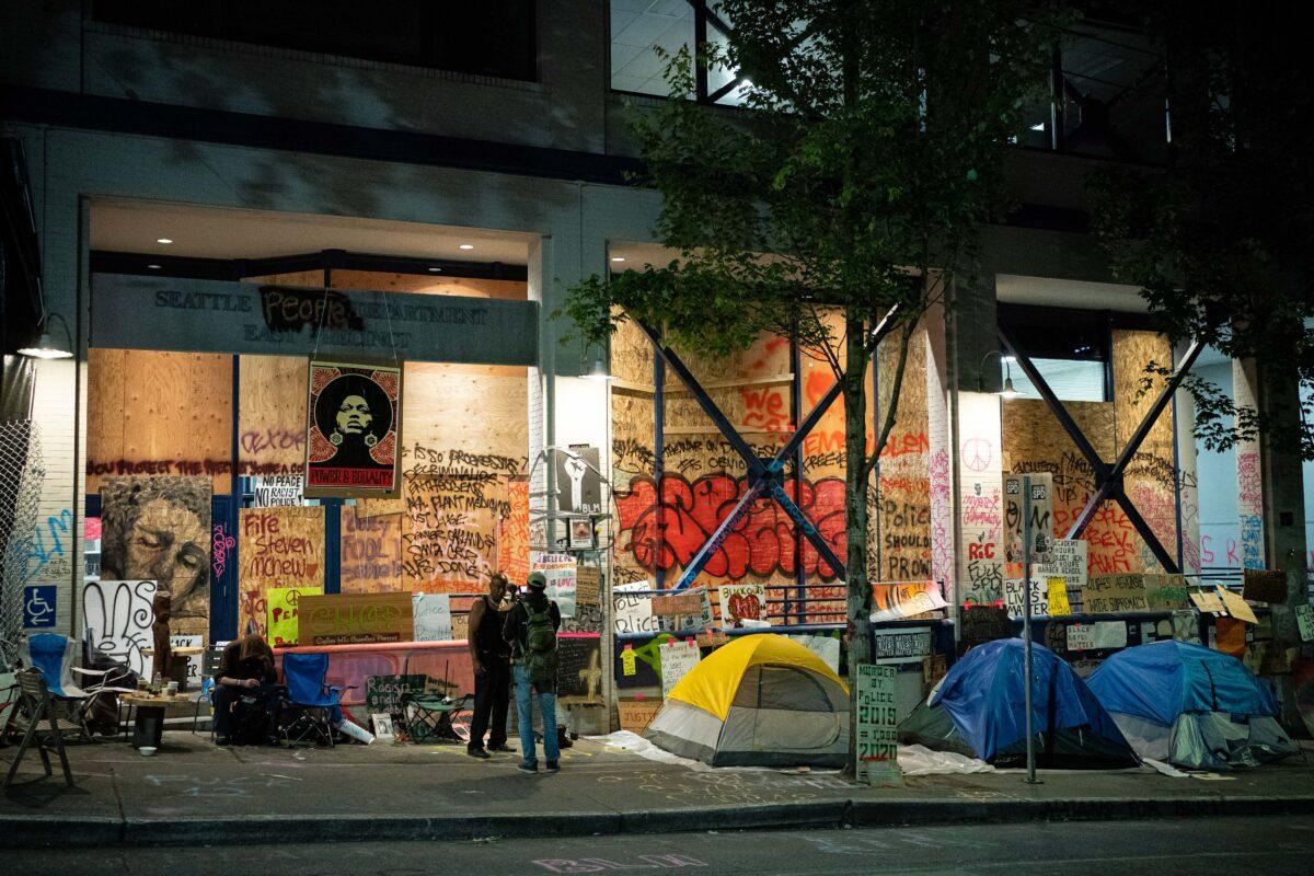 People stand near tents set up outside of the Seattle Police Department's vacated East Precinct in the area known as the Capitol Hill Organized Protest (CHOP) in Seattle, Wash. on June 23, 2020. (David Ryder/Getty Images)