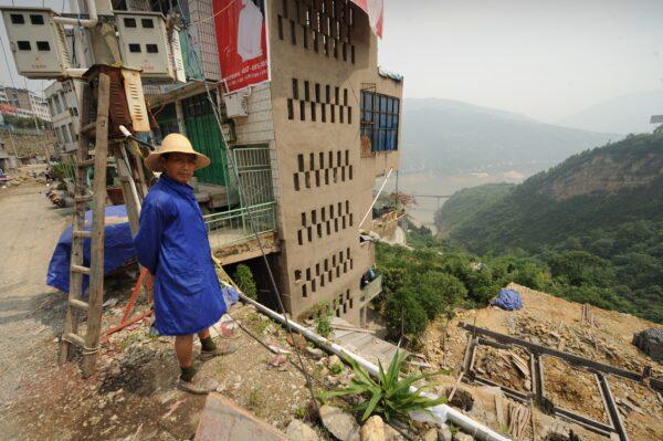 In a picture taken on June 16, 2011, a resident looks out at the site where last October, a huge chunk of hillside broke free in Badong, in Hubei province, on the Yangtze River. (Peter Parks/AFP via Getty Images)