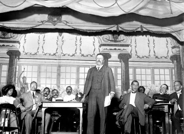 Theodore Roosevelt speaking at the National Negro Business League in 1910. Seated to his left is Booker T. Washington. (Everett Collection /Shutterstock)