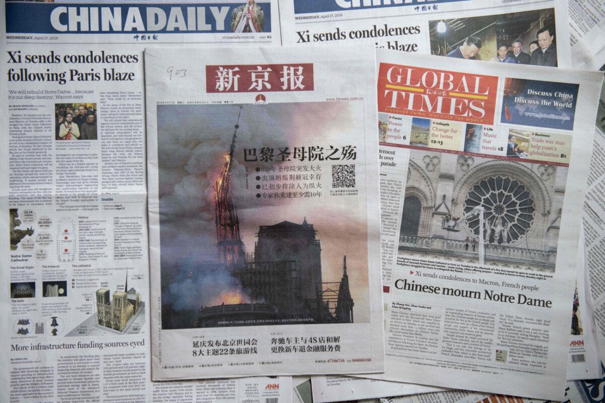 Front pages of the China Daily (L), the Beijing News (C) and the Global Times (R) featuring the Notre-Dame Cathedral disaster, in Beijing on April 17, 2019. (Nicolas Asfouri/AFP via Getty Images)