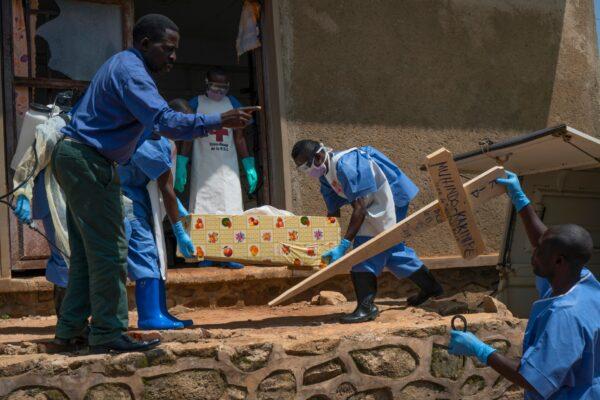 Red Cross workers carry the remains of 16-month-old Muhindo Kakinire, who died of Ebola, from the morgue into a truck as health workers disinfect the area in Beni, Congo, on July 14, 2019. (Jerome Delay, File/AP Photo)