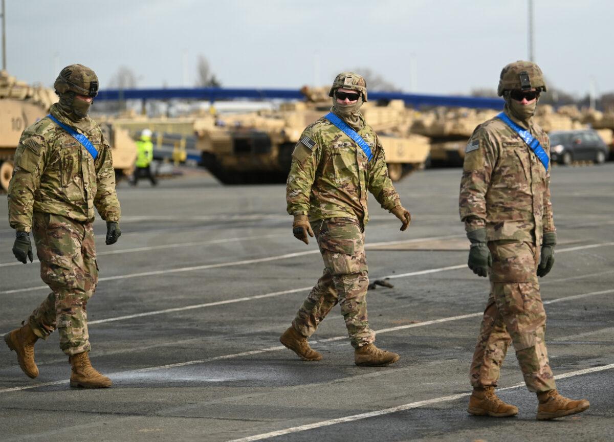  U.S. soldiers walk alongside M1 Abrahams battle tanks from the U.S. 2nd Brigade Combat Team, 3rd Infantry Division, in Bremerhaven, Germany, on Feb. 21, 2020. (David Hecker/Getty Images)