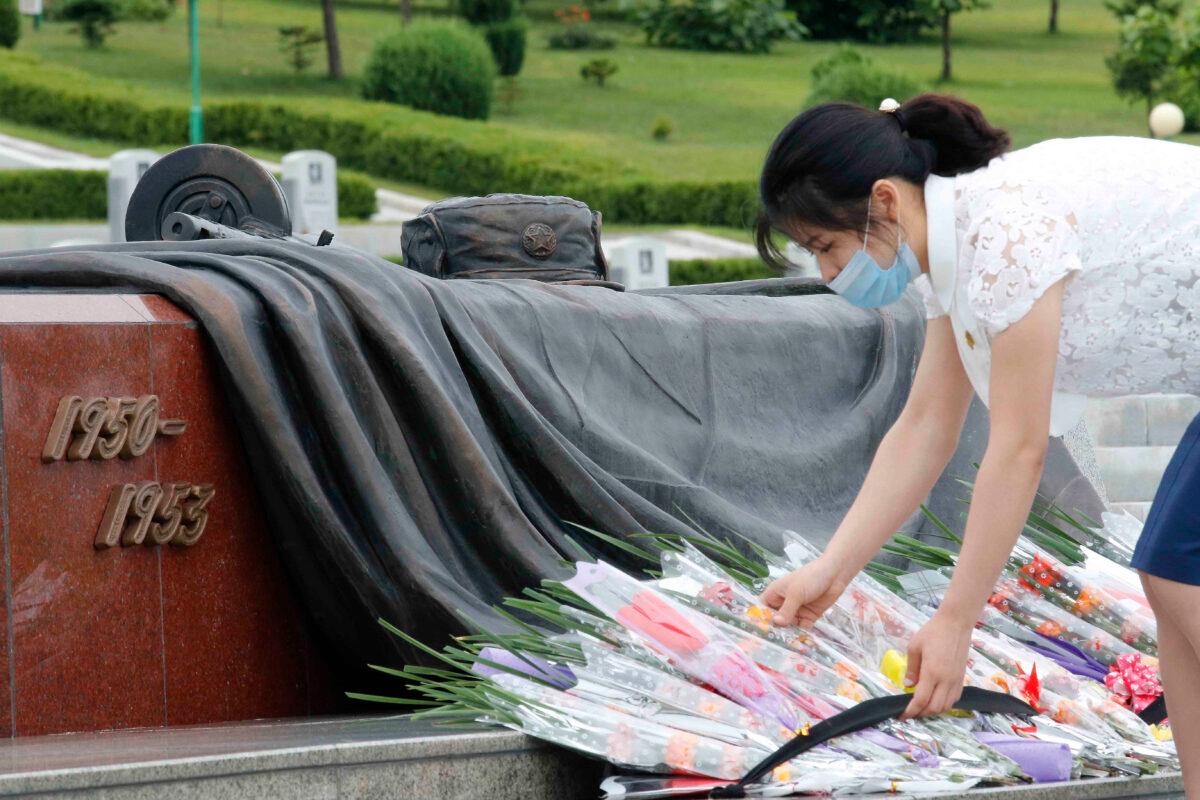 A North Korean woman lays a bouquet of flowers during a visit to the Fatherland Liberation War Martyrs Cemetery to pay respects to the monument to the fallen soldiers of the Korean People's Army in Pyongyang, North Korea, on June 25, 2020. (Jon Chol Jin/AP Photo)