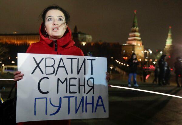 A protester holds a poster that reads, "Enough Putin for me," in front of the monument of the Prince Vladimir next to the Kremlin in Moscow, Russia, on March 11, 2020. (Pavel Golovkin, File/AP Photo)