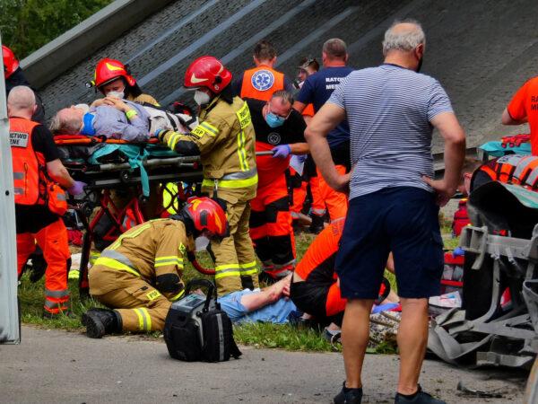 First responders treat the injured at the scene of a public bus crash, where the bus fell from a viaduct on the Armia Krajowa route in Warsaw, Poland, on June 25, 2020. (Agencja Gazeta/Dariusz Borowicz via Reuters)
