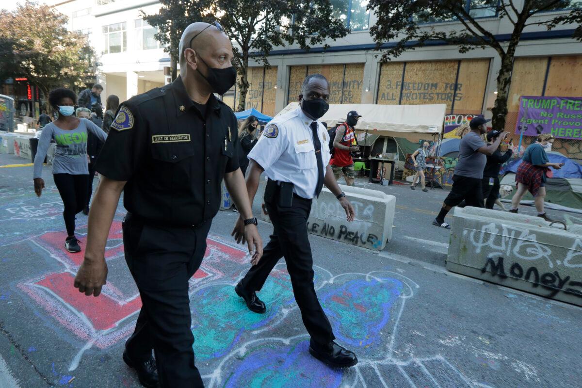  Seattle Fire Chief Harold Scoggins (R) and Assistant Chief Willie Barrington (L) walk inside the CHOP (Capitol Hill Occupied Protest) zone in Seattle, Wash., on June 26, 2020. (Ted S. Warren/AP Photo)