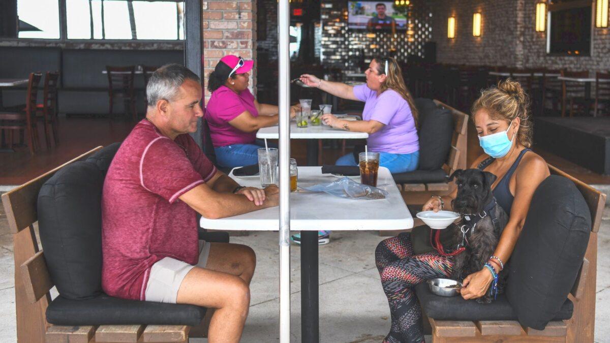 People eat sitting outside of a restaurant on Fort Lauderdale Beach Boulevard in Fort Lauderdale, Fla., on May 18, 2020. (Chandan Khanna/AFP via Getty Images)