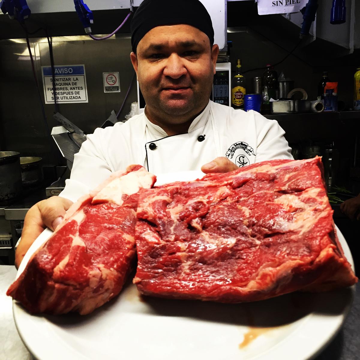 A chef holds up the steak destined for cooking at Don Julio restaurant in Buenos Aires, Argentina. (Tim Johnson)