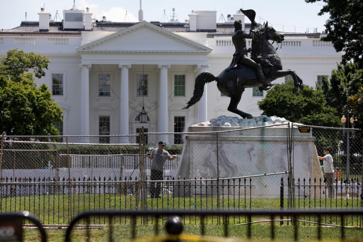 The base of the statue of former president Andrew Jackson is power washed inside a newly closed Lafayette Park, in Washington, on June 24, 2020. (AP Photo/Jacquelyn Martin)