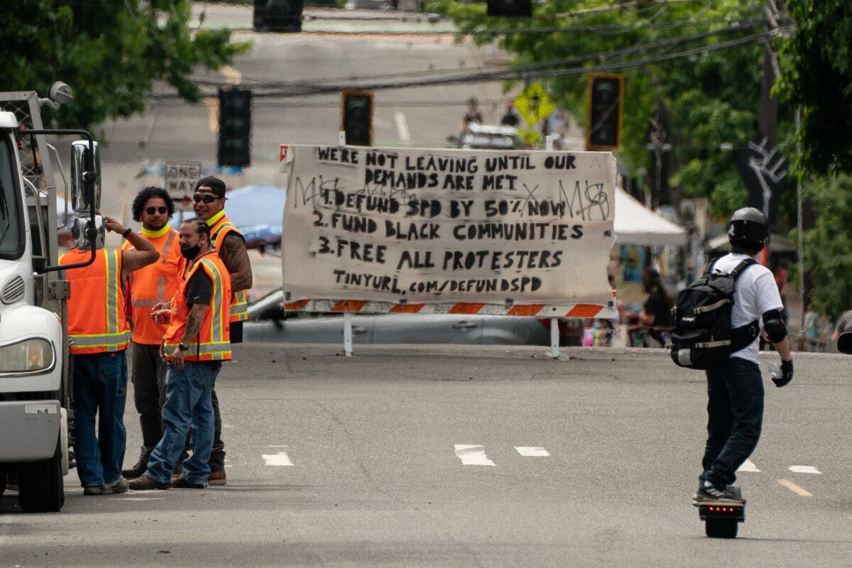 Personnel from the Seattle Department of Transportation wait near an entrance to the area known as the Capitol Hill Organized Protest (CHOP) in Seattle, on June 26, 2020. (David Ryder/Getty Images)