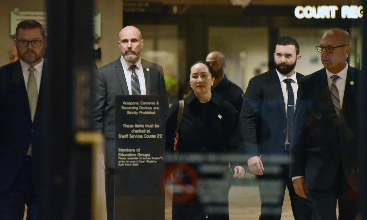 Huawei chief financial officer Meng Wanzhou, after a short morning session that ended the fourth day of trial in her extradition case, leaves British Columbia Supreme Court in Vancouver with her security detail on Jan. 23, 2020. (Don Mackinnon/AFP via Getty Images)