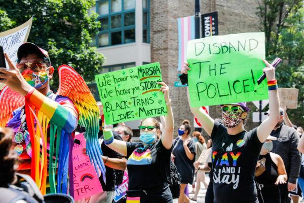 Protesters hold signs during a march in Chicago, Ill., on June 28, 2020. (Natasha Moustache/Getty Images)