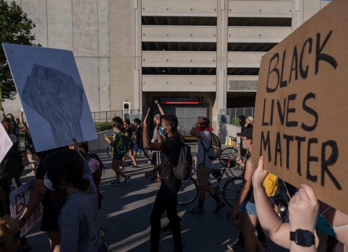 Protesters walk past the entrance to Little Caesars Arena in Detroit, on June 7, 2020. (Seth Herald/AFP via Getty Images)