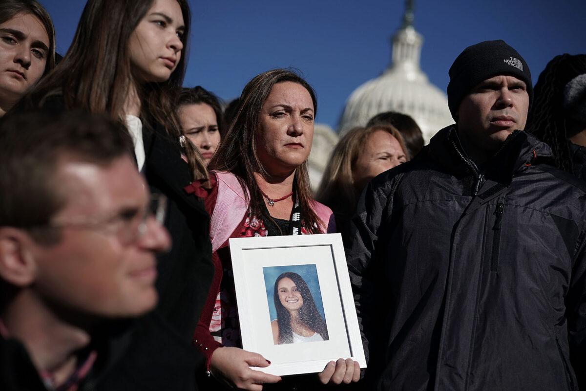 Lori Alhadeff (C) and her husband Ilan Alhadeff (R) hold a picture of their daughter Alyssa Alhadeff during a news conference on gun control on Capitol Hill in Washington on March 23, 2018 (Alex Wong/Getty Images)