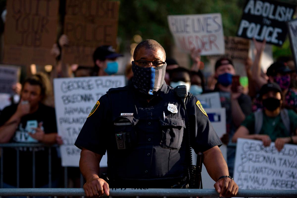 A police officer stands between Police Appreciation rally attendees and counter-protesters at the City Hall in Houston, Texas, on June 18, 2020. (Mark Felix/AFP via Getty Images)