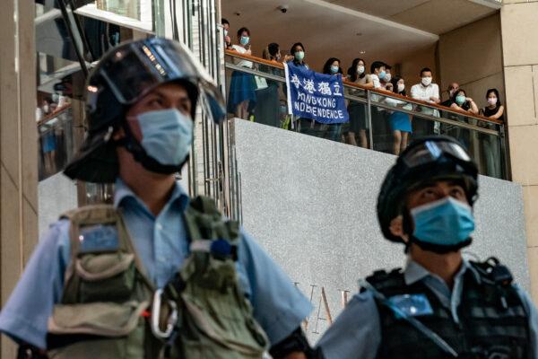 Pro-democracy supporters hold a Hong Kong Independence flag and shout slogans during a rally against the national security law as riot police secure an area in a shopping mall in Hong Kong on June 30, 2020. (Anthony Kwan/Getty Images)