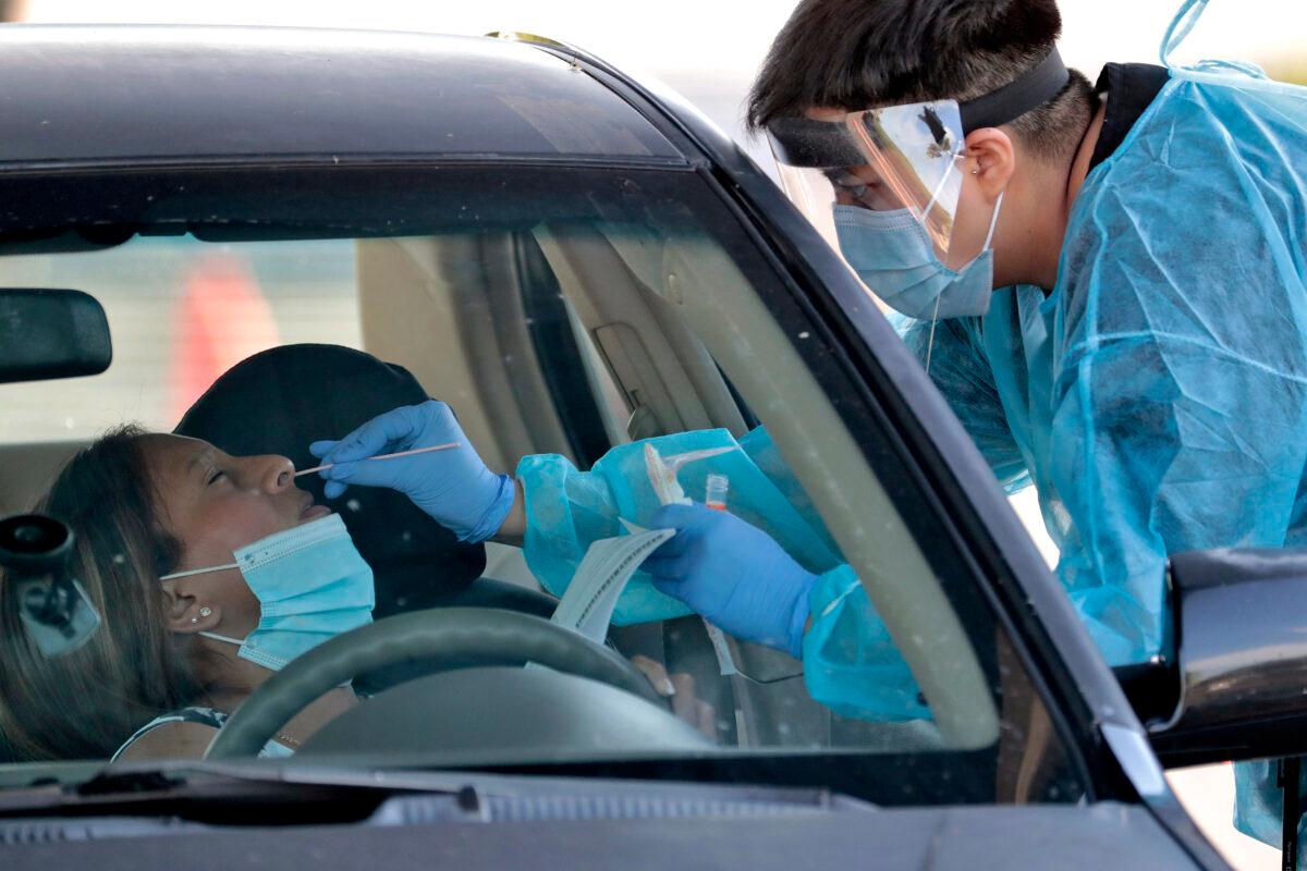 People are tested in their vehicles in Phoenix's western neighborhood of Maryvale in Phoenix for free COVID-19 tests organized by Equality Health Foundation, which focuses on care in underserved communities, in Phoenix, Ariz., June 27, 2020. (Matt York/AP Photo)