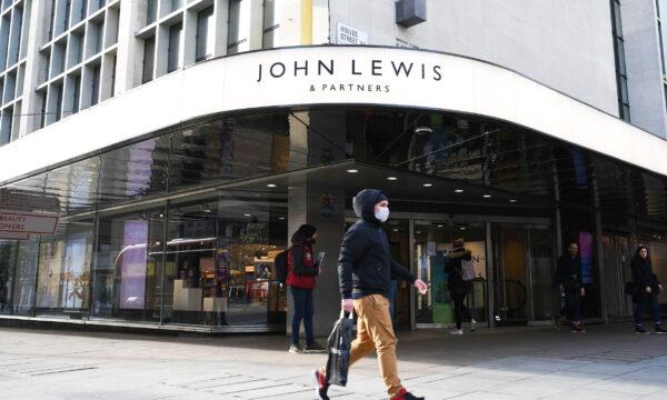 A man wearing a protective face mask walks past the front entrance of John Lewis department store on Oxford Street in central London on the afternoon of March 21, 2020. (Daniel Leal-Olivas/AFP via Getty Images)