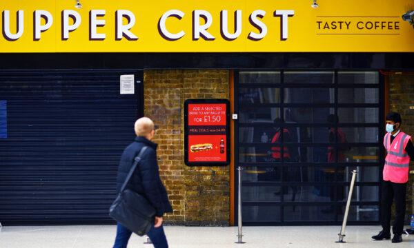 A pedestrian walks past a closed-down and shuttered Upper Crust food outlet in Charing Cross train station in London, UK, on July 1, 2020. (Ben Stansall/AFP via Getty Images)