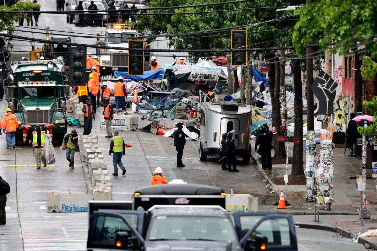 Police and city workers fill a street occupied hours earlier by an encampment of protesters, in Seattle on July 1, 2020. (Elaine Thompson/AP Photo)