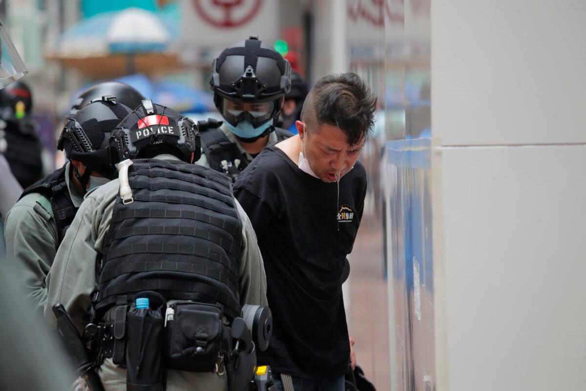 Police detain a protester after sprayed pepper spray on his face during a protest in Causeway Bay before the annual handover march in Hong Kong on July 1, 2020. (Kin Cheung/AP)