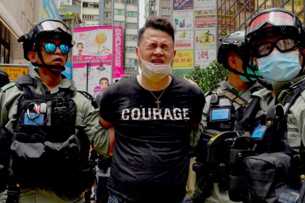 Police detain a protester after spraying pepper spray during a protest in Causeway Bay before the annual handover march in Hong Kong on July 1, 2020. (Vincent Yu/AP)