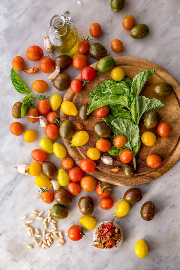 In a pan on the stovetop, tiny, plump cherry tomatoes burst from the heat and melt into the olive oil. (Photo by Giulia Scarpaleggia)