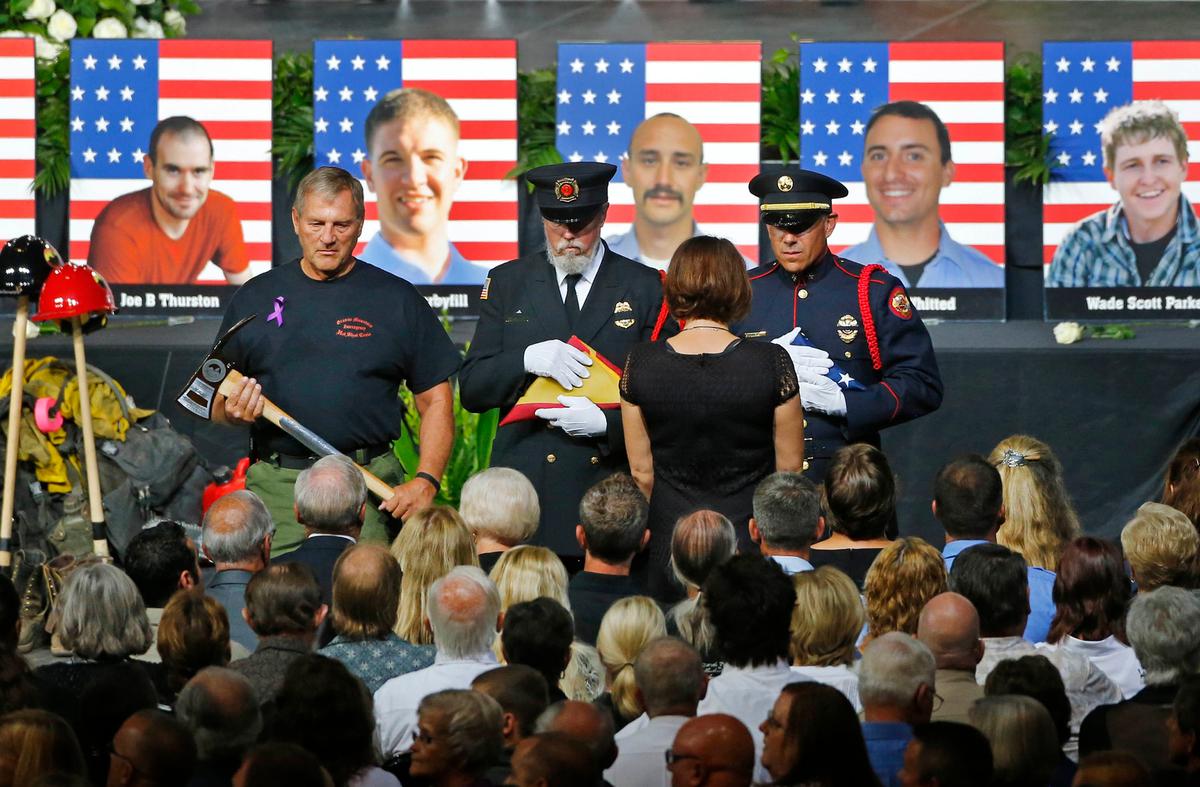 An honor guard presents families with an American Flag during a memorial service at Tim's Toyota Center July 9, 2013, in Prescott Valley, Arizona. (David Kadlubowski-Pool/Getty Images)