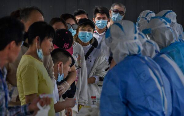 People wait in line for nucleic acid swab tests for COVID-19 at a testing site in Beijing on July 1, 2020. (Kevin Frayer/Getty Images)