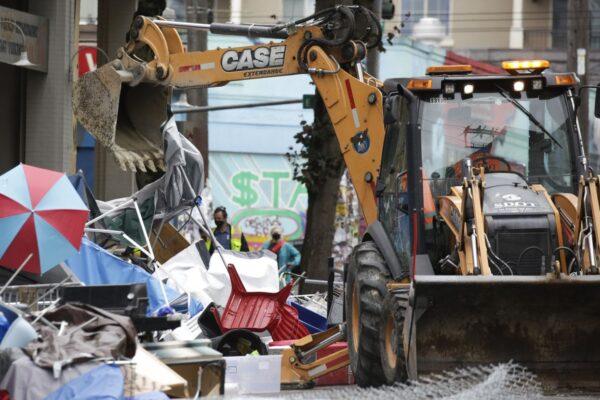 Workers use a bulldozer to remove remaining items from an encampment outside the Seattle Police Department's East Precinct after police cleared the Capitol Hill Occupied Protest (CHOP) in Seattle, Washington, on July 1, 2020. (Jason Redmond/AFP via Getty Images)