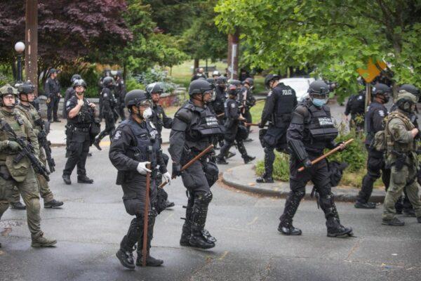 Seattle Police finish their sweep on July 1, 2020, on the north end of Cal Anderson Park, sweeping everyone off the grounds. (Steve Ringman/The Seattle Times via AP)