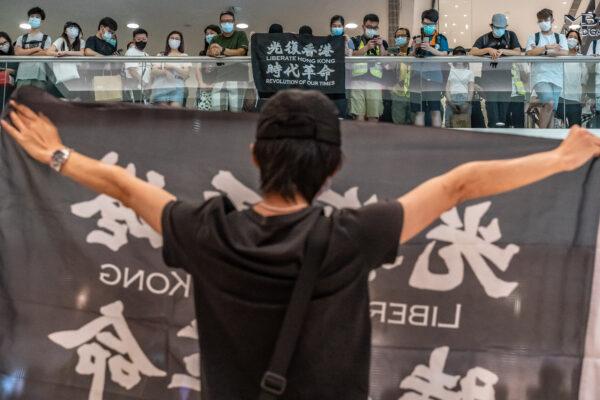 Anti-government protesters wearing protective masks hold Liberate Hong Kong, Revolution of Our Times banners during a demonstration at a shopping mall in Hong Kong, on May 10, 2020. (Anthony Kwan/Getty Images)