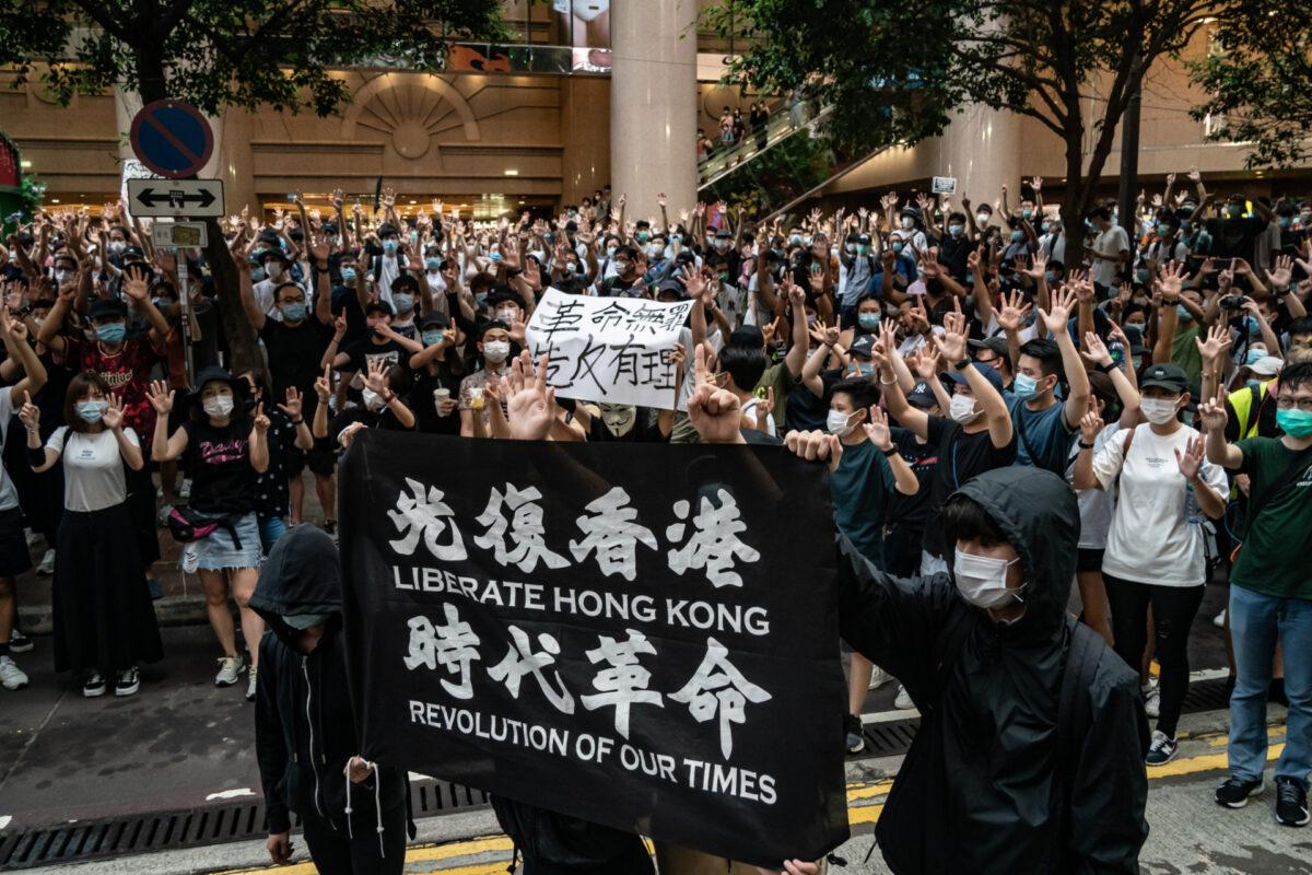 Riot police detain a man as they raise a warning flag during a demonstration against the new national security law in Hong Kong on July 1, 2020. (Anthony Kwan/Getty Images)