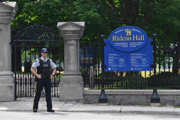 A police officer stands by a fence outside Rideau Hall in Ottawa on July 2, 2020. The RCMP say they have safely resolved an "incident" at Rideau Hall, where Gov. Gen. Julie Payette and Prime Minister Justin Trudeau live. (THE CANADIAN PRESS/Adrian Wyld)