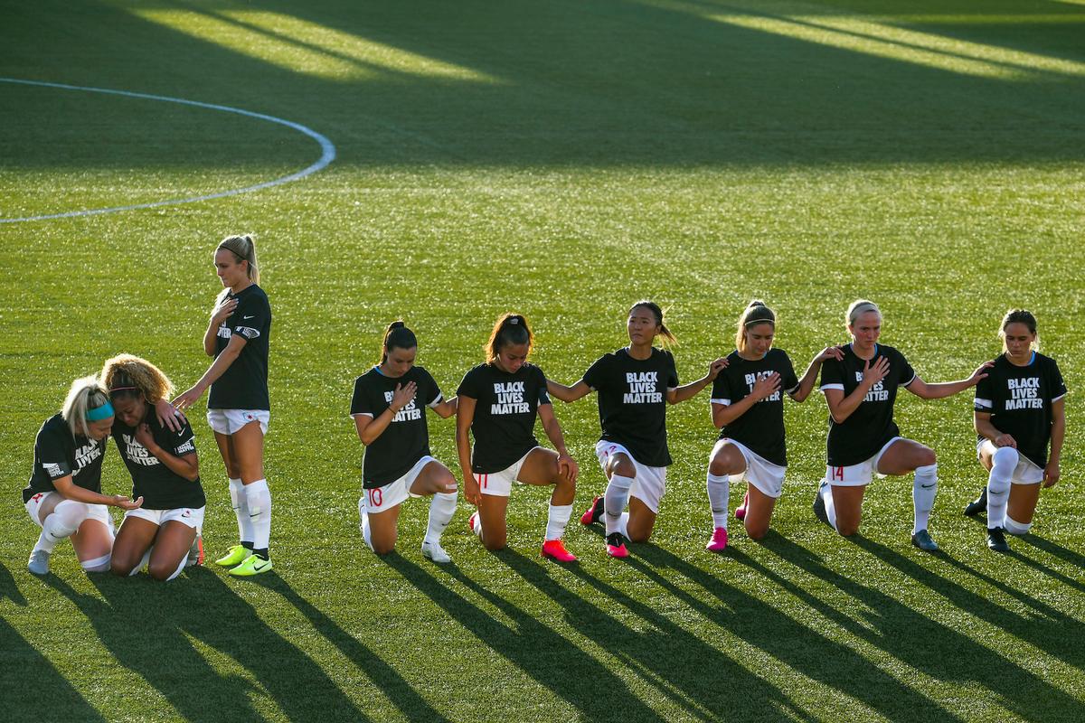 Rachel Hill ,#5, consoles Casey Short ,#6, of the Chicago Red Stars as teammates kneel during the national anthem before a game against the Washington Spirit at Zions Bank Stadium on June 27, in Herriman, Utah. (Alex Goodlett/Getty Images)