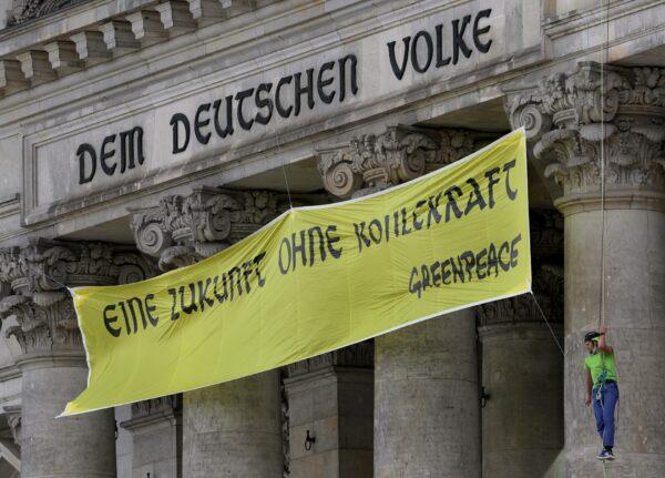 Activists of Greenpeace covered the inscription 'Dem Deutschen Volke' (To the German People) on top of the entrance of the Reichstag building, home of the German parliament Bundestag, with the slogan 'Eine Zukunft Ohne Kohlekraft' (a future without coal power) in Berlin, on July 3, 2020. (Michael Sohn/AP Photo)