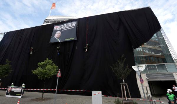 Activists of Greenpeace have covered the headquarters of German Chancellor Angela Merkel's Christian Democratic Party (CDU) with black panels to protest against the party's coal policy in Berlin, on July 1, 2020. (Michael Sohn/AP Photo)