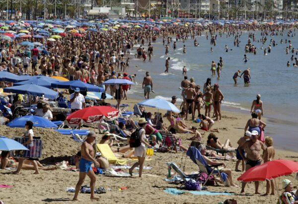 People visit the beach in the Spanish south-eastern town of Benidorm, on March 31, 2015. (Heino Kalis/Reuters)