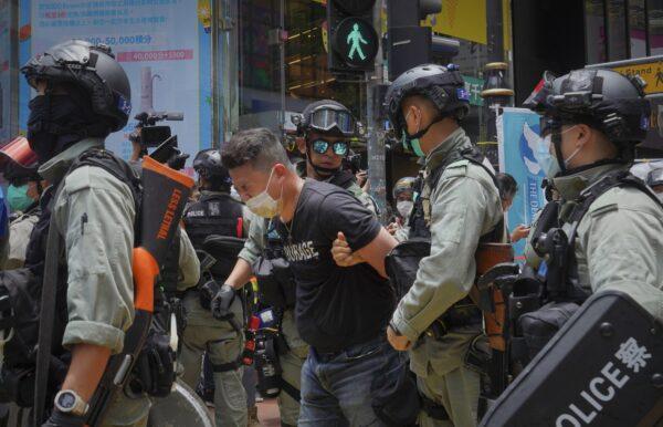 Police detain a protester after spraying pepper spray during a protest in Causeway Bay before the annual handover march in Hong Kong on July 1, 2020. (Vincent Yu/AP Photo)