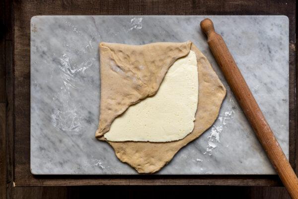 Enclose the butter in an envelope of dough and pinch the edges to seal. (Photo by Giulia Scarpaleggia)