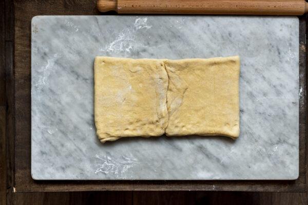 Rotate the dough 90 degrees, roll it out into a rectangle four times its length, and fold the two ends in so they meet in the middle. (Photo by Giulia Scarpaleggia)