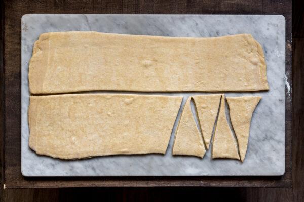 Roll out the dough, cut it in half, and cut each strip into triangles. (Photo by Giulia Scarpaleggia)
