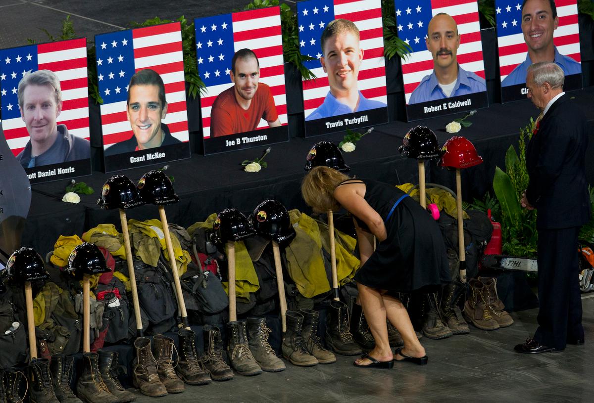 A tribute to the 19 fallen firefighters lines the front of the stage before a memorial service at Tim's Toyota Center in Prescott Valley, Ariz., July 9, 2013 (Michael Chow-Pool/Getty Images)