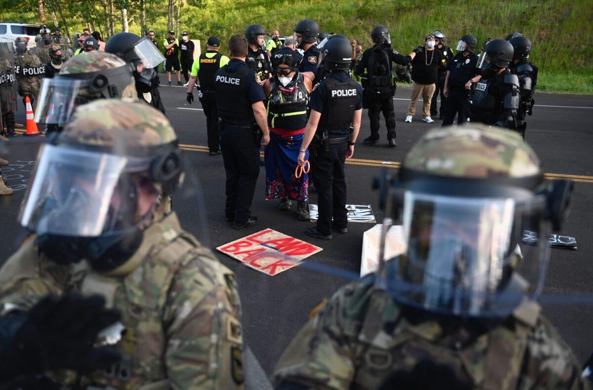 Police arrest people as activists and members of different tribes from the region who blocked the road to Mount Rushmore National Monument in Keystone, S.D., on July 3, 2020. (Andrew Caballero-Reynolds/AFP via Getty Images)