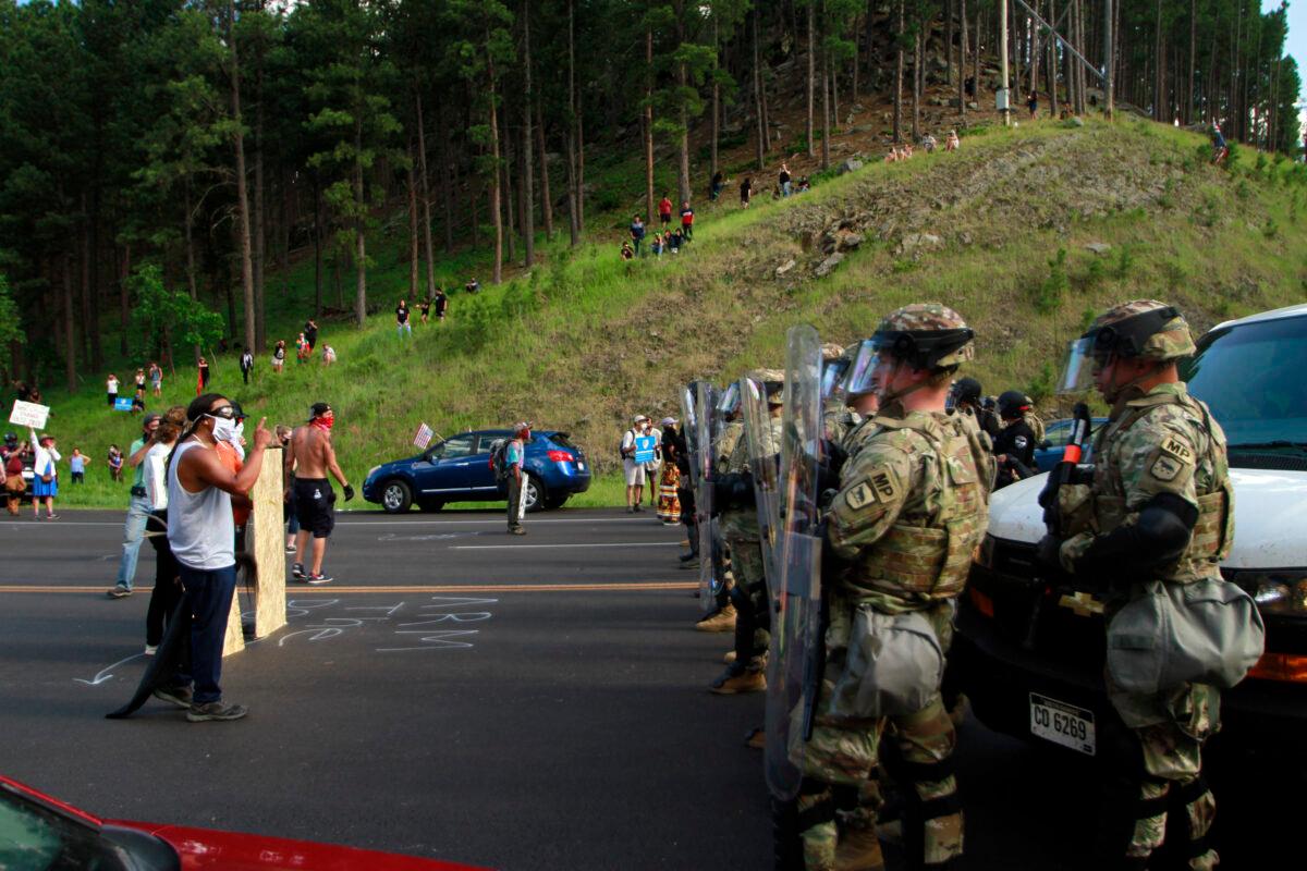 Protesters confront a line of law enforcement officers on the road leading to Mount Rushmore ahead of President Donald Trump's visit to the memorial in Keystone, S.D., on July 3, 2020. (Stephen Groves/AP Photo)