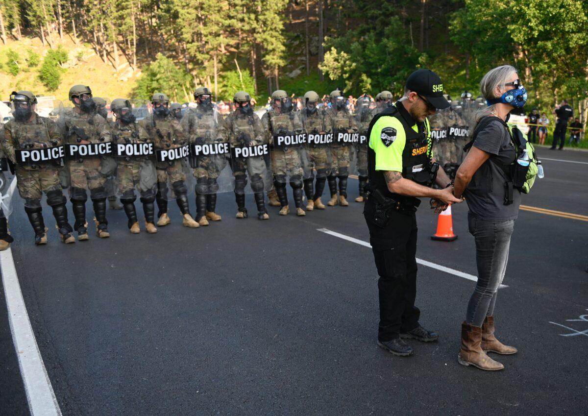 A sheriff's deputy arrests a protester who helped block the road to Mount Rushmore National Monument in Keystone, S.D., on July 3, 2020. (Andrew Caballero-Reynolds/AFP via Getty Images)