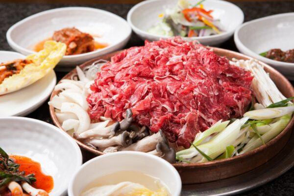 Seoul-style bulgogi is notably cooked atop a domed copper plate, with the juices trickling down into a built-in moat filled with broth and veggies. (TMON/Shutterstock)