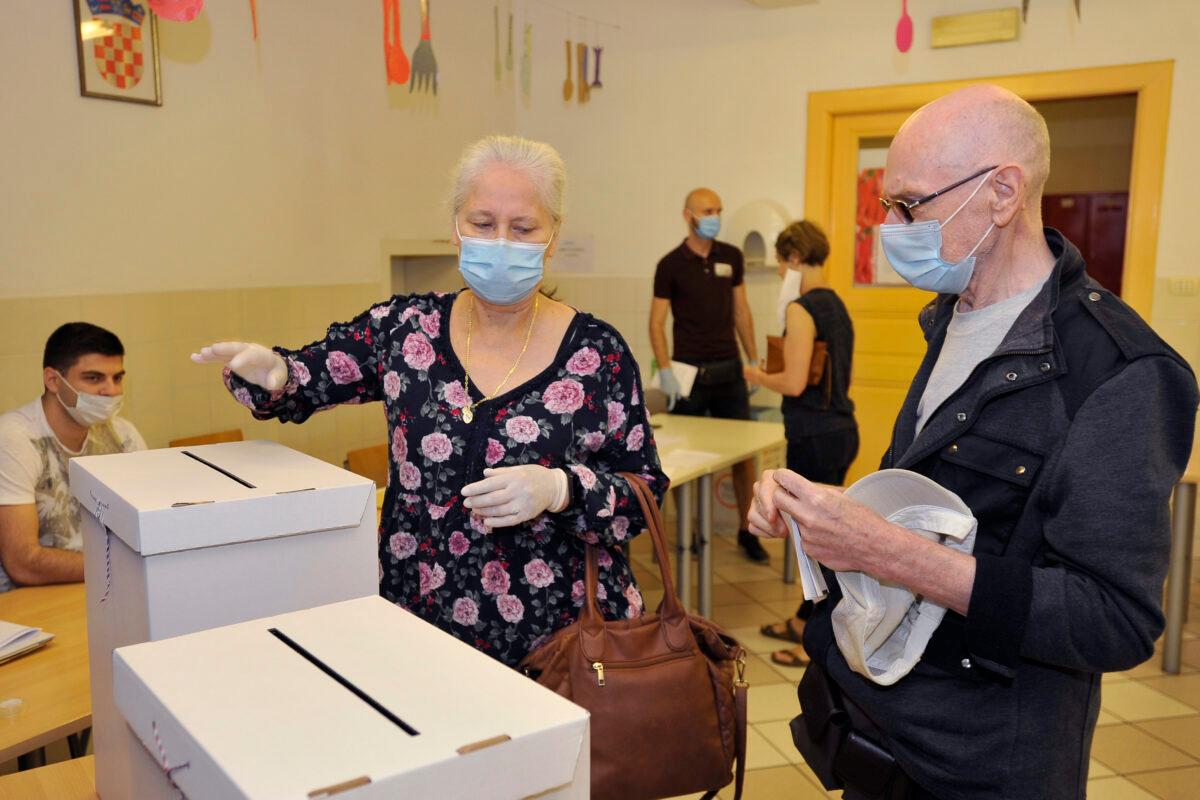 Voters cast ballots at a polling station in Zagreb, Croatia, on July 5, 2020. (AP Photo)