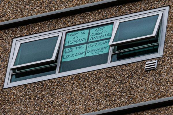A sign is stuck to a window reading 'Treat us as humans, not caged animals' and 'End this lockdown effective immediately' at the Flemington Public housing flats in Melbourne, Australia, on July 5, 2020. (Asanka Ratnayake/Getty Images)